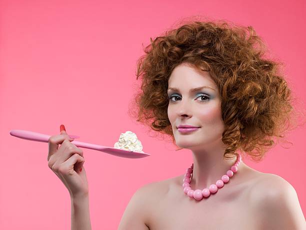portrait of beautiful young black woman with curly hair posing at gray background