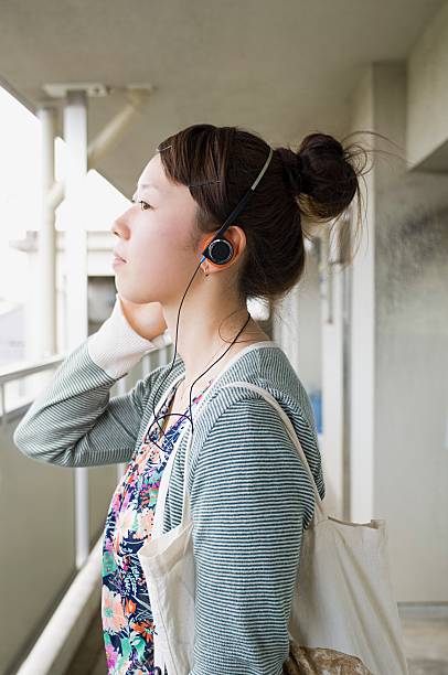 mulheres jovens usar auscultadores - hair bun asian ethnicity profile women imagens e fotografias de stock