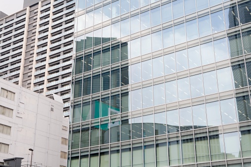 Closeup glass wall of office building with reflection of city, background with copy space, full frame horizontal composition