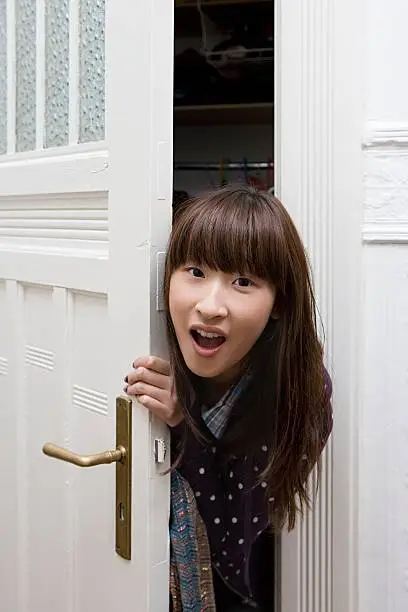 Photo of Young woman opening door