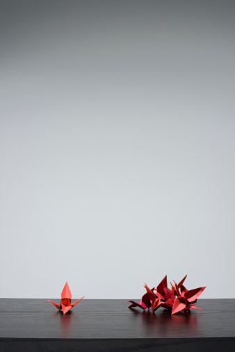 Origami art. Beautiful red paper crane on orange background, space for text