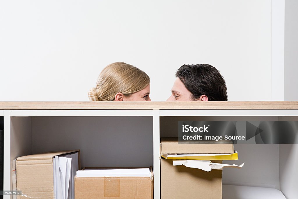 Woman and man behind shelves  Flirting Stock Photo