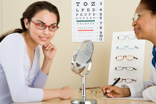Close-up on a pair of eyeglasses on an eye chart - eye exam concepts