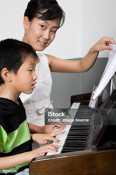 Foto de Um Professor Ajudar Aluno Jogar Piano e mais fotos de stock de Meninos - Meninos, Piano, Adulto
