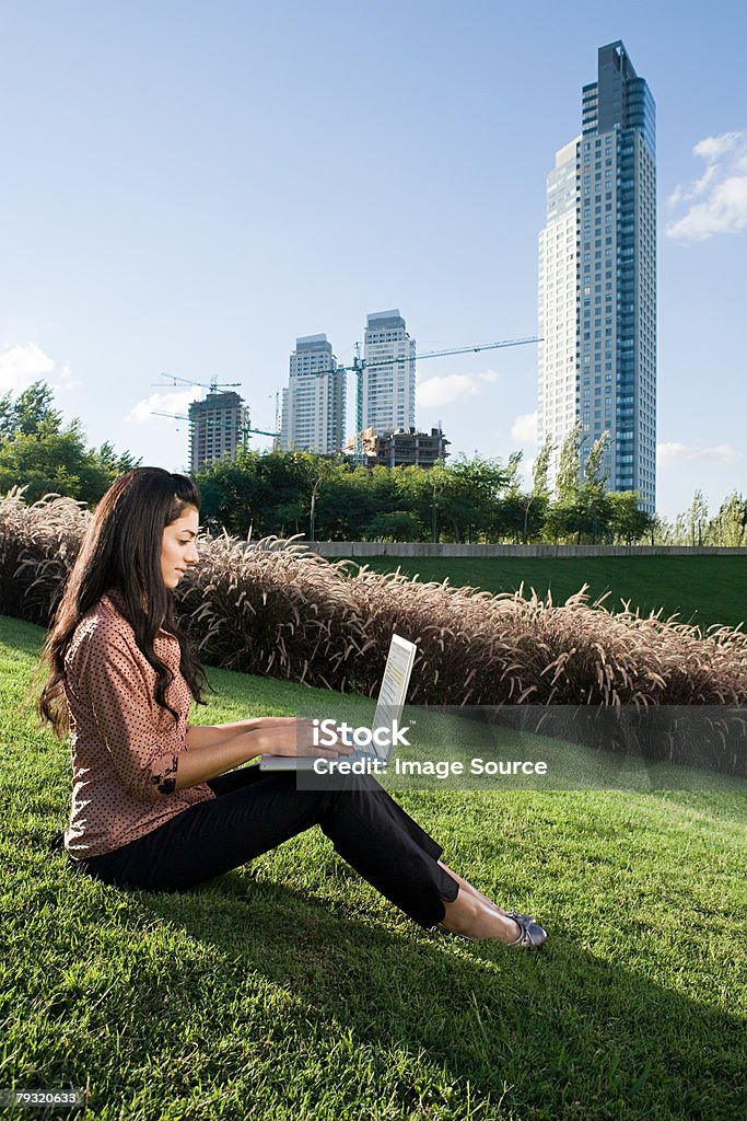 Kobieta za pomocą laptopa na hill - Zbiór zdjęć royalty-free (Biurowiec)