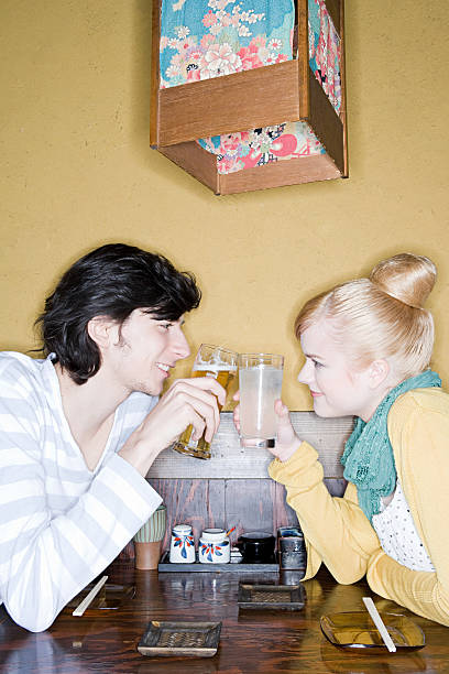 una giovane coppia brindando - glasses women smiling human face foto e immagini stock