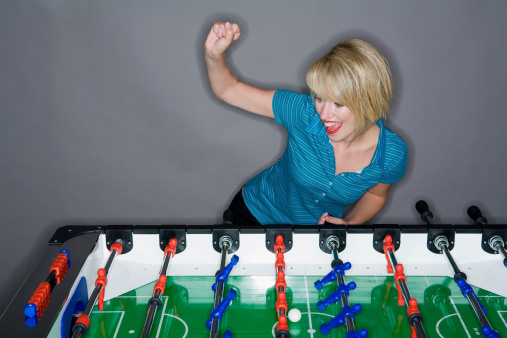 Foosball game with people in the background.