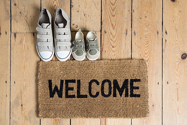 Training shoes and a welcome mat  running shoes on floor stock pictures, royalty-free photos & images