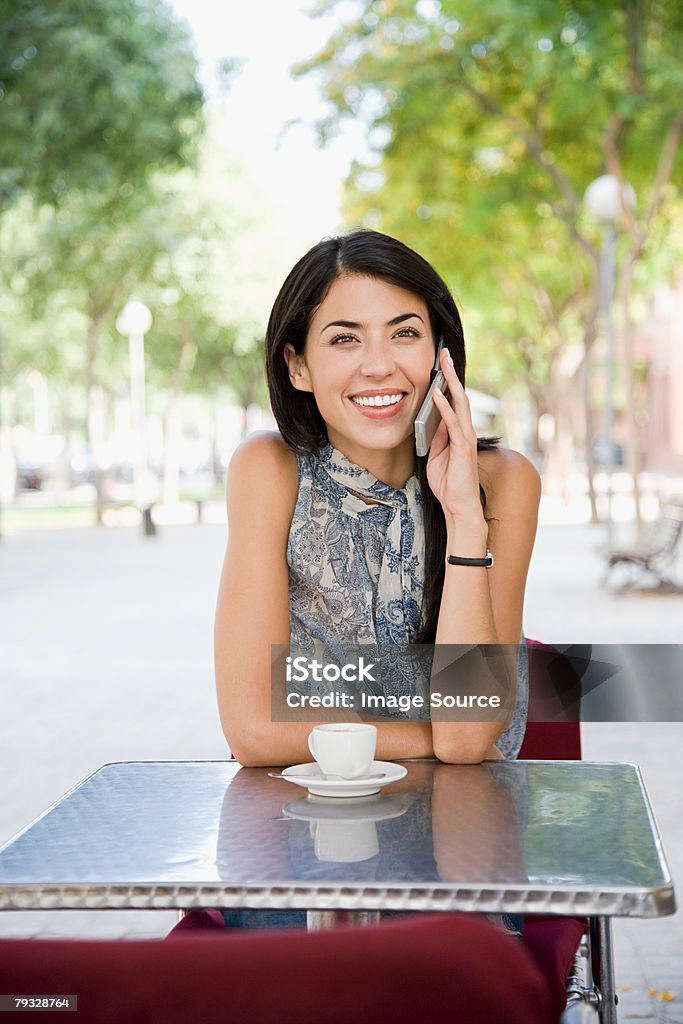 Donna con cellulare in Café - Foto stock royalty-free di Adulto