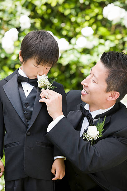 Groom and boy smelling flower  ring bearer stock pictures, royalty-free photos & images