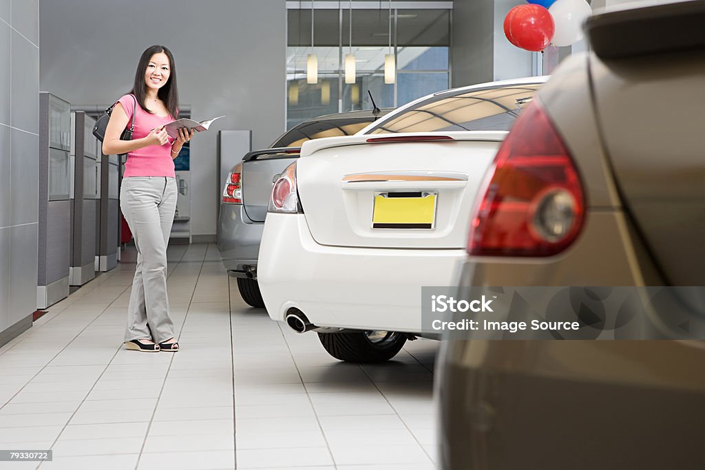 Woman in car dealership - Photo de Acheter libre de droits