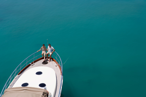 Couple standing on luxury yacht in Adriatic sea against city, Split, Croatia.