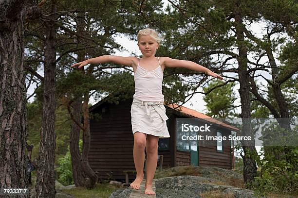 Foto de Uma Menina Caminhando Ao Longo De Uma Tábua De Madeira e mais fotos de stock de Andar