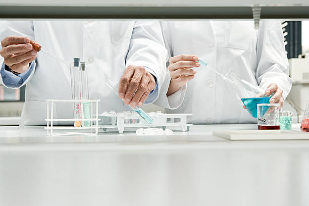 scientists conducting an experiment - laboratory laboratory equipment chemistry science стоковые фото и изображения