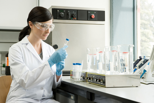 hand of scientist holding flask with lab glassware in chemical laboratory background, science laboratory research and development concept