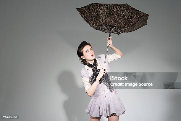 Młoda Kobieta Trzymając Parasol - zdjęcia stockowe i więcej obrazów Barwne tło - Barwne tło, Kobiety, Parasol