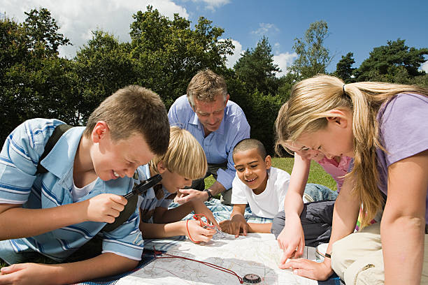 Teacher and pupils looking at map  orienteering stock pictures, royalty-free photos & images