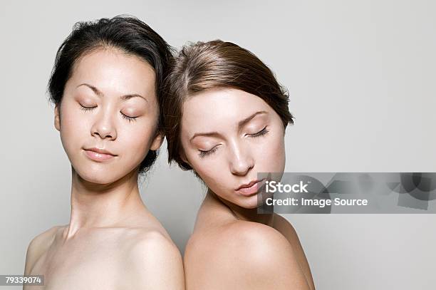 Retrato De Duas Mulheres Com Os Olhos Fechados - Fotografias de stock e mais imagens de Mulheres - Mulheres, Costas Com Costas, Beleza