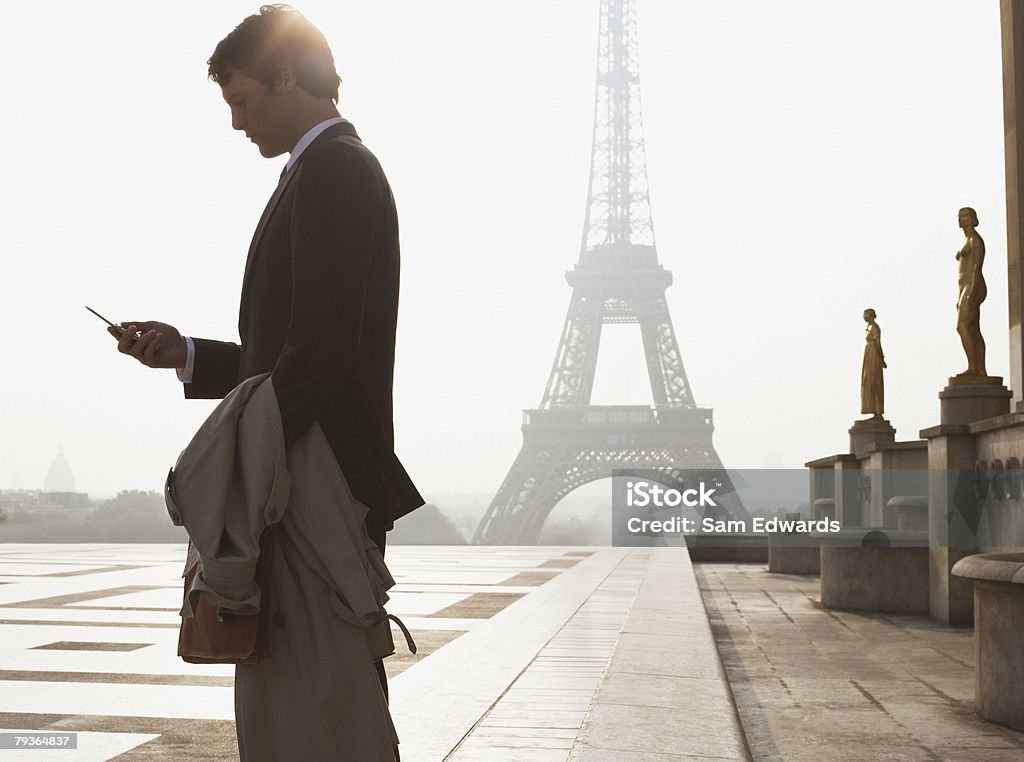 Businessman outdoors with cellular phone by Eiffel Tower  Paris - France Stock Photo