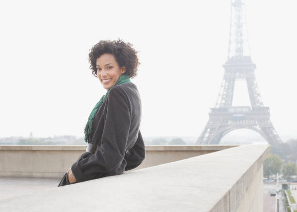 mujer de negocios al aire libre junto a la torre eiffel - high key portrait color image travel locations fotografías e imágenes de stock