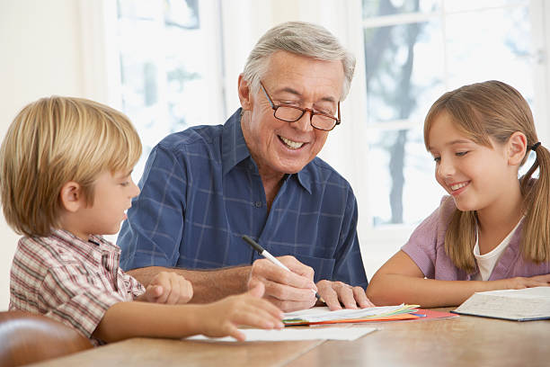 człowiek pomaga dwoje dzieci z zadanie domowe w kitchen table - dining table child grandparent grandchild zdjęcia i obrazy z banku zdjęć