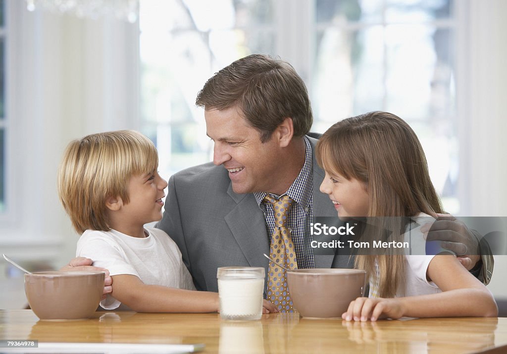 Homme et deux jeunes enfants en cuisine Liens affectifs - Photo de Céréales du petit déjeuner libre de droits