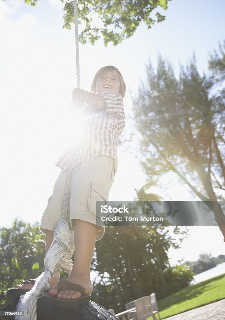 Giovane ragazzo all'aperto in un parco giocando su altalene - Foto stock royalty-free di 4-5 anni