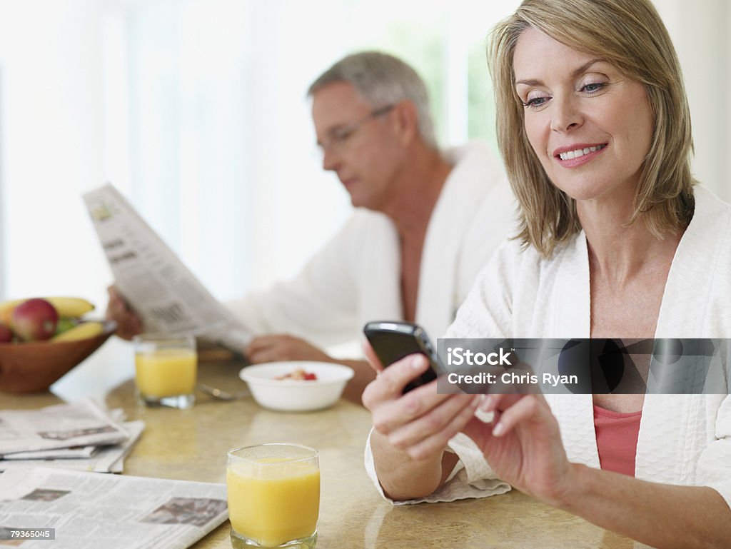 Couple dans la cuisine manger le petit déjeuner et lire le journal - Photo de Lire libre de droits