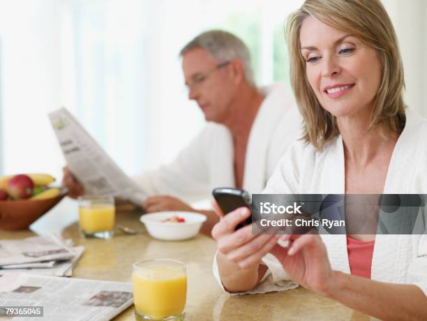 Photo libre de droit de Couple Dans La Cuisine Manger Le Petit Déjeuner Et Lire Le Journal banque d'images et plus d'images libres de droit de Lire