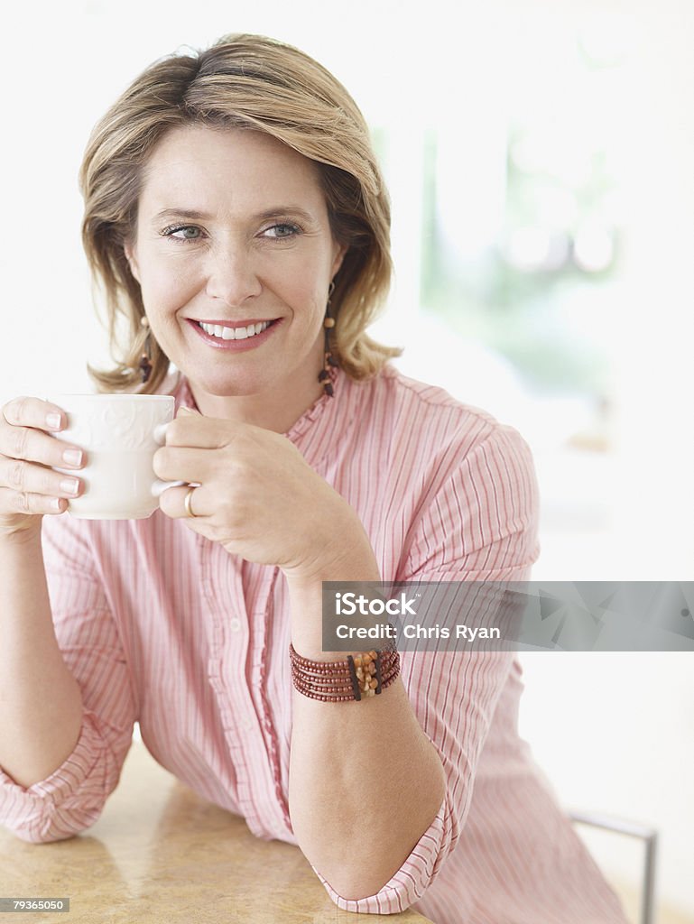 Woman in kitchen with mug  45-49 Years Stock Photo