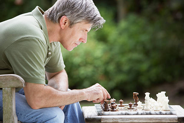 uomo di giocare a scacchi all'aria aperta - focus on foreground selective focus focus household equipment foto e immagini stock