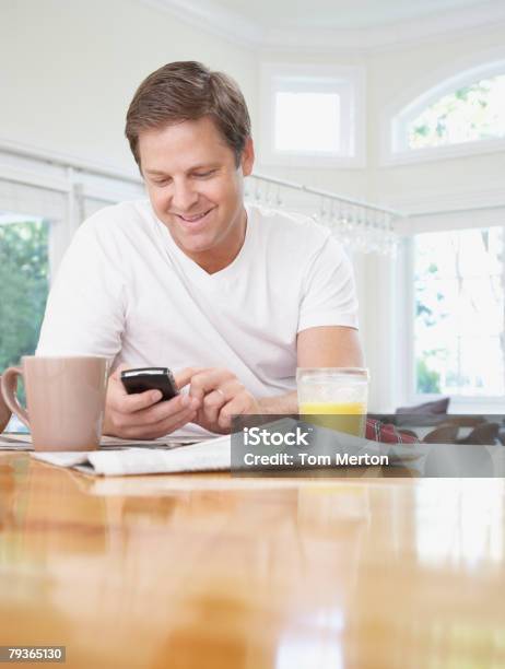 Man In Kitchen Using His Mobile Phone Stock Photo - Download Image Now - 40-44 Years, Adults Only, Breakfast