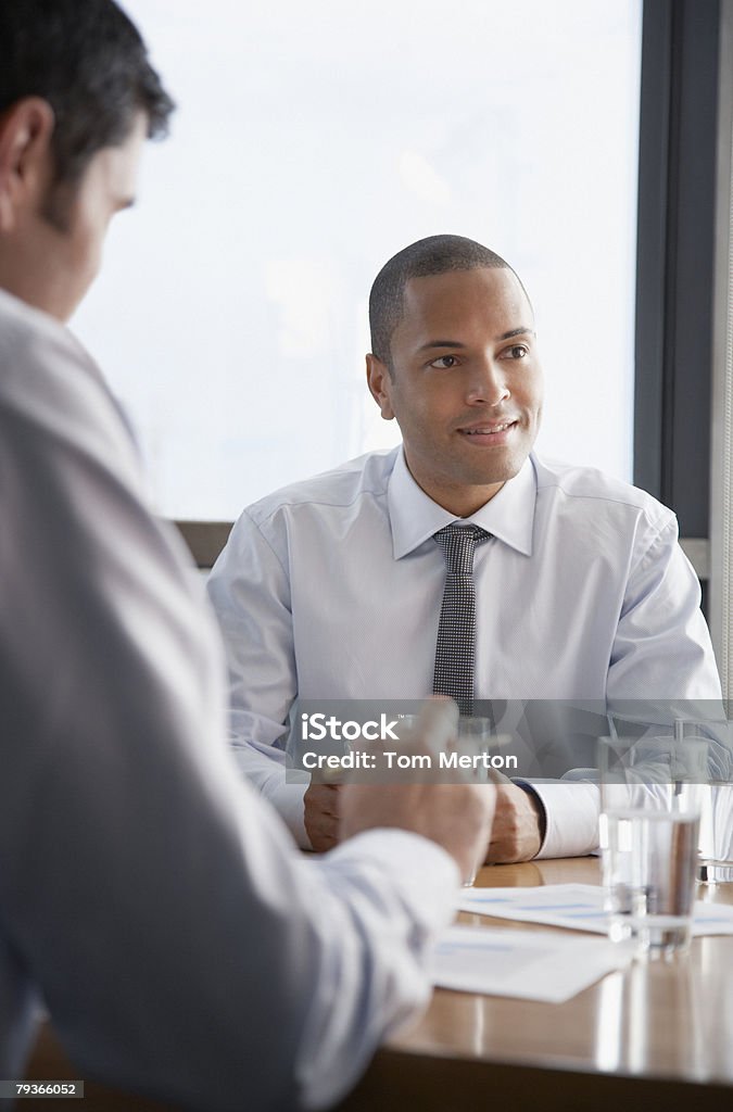 Dois homens de negócios com sala de diretoria com papelada - Foto de stock de 30-34 Anos royalty-free