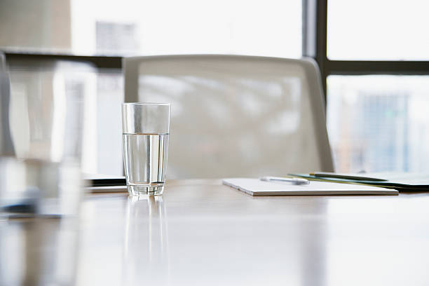 leere boardroom stuhl mit schreibutensilien und gläser - office water business meeting stock-fotos und bilder
