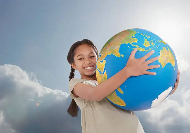 Photo of Young girl outdoors holding a large globe
