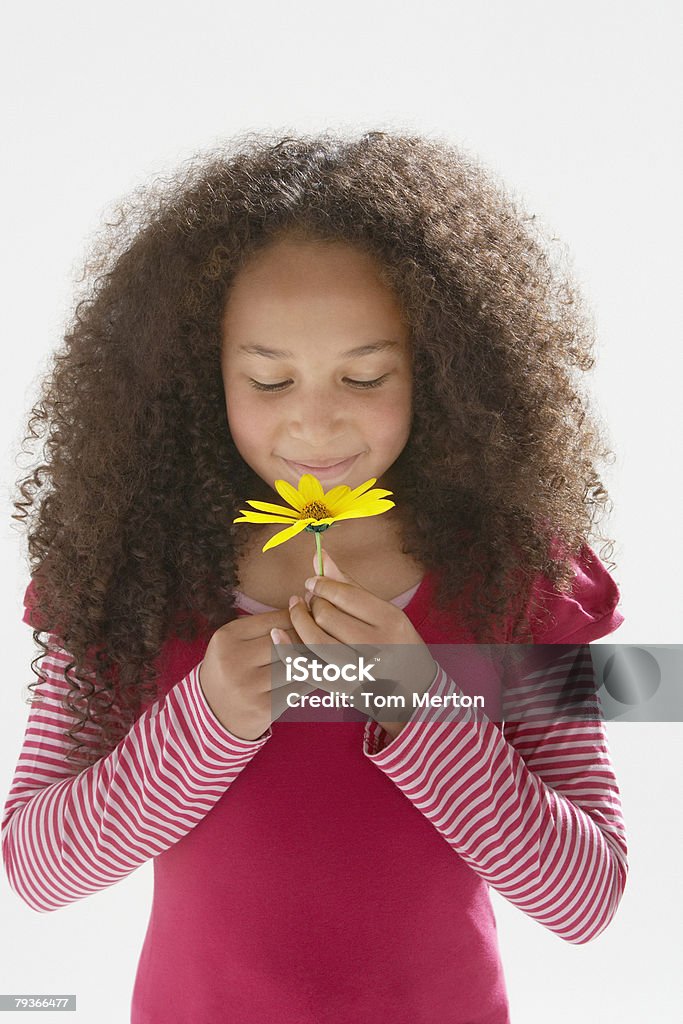 Młoda dziewczyna zapachu kwiatów w domu - Zbiór zdjęć royalty-free (Wąchać)