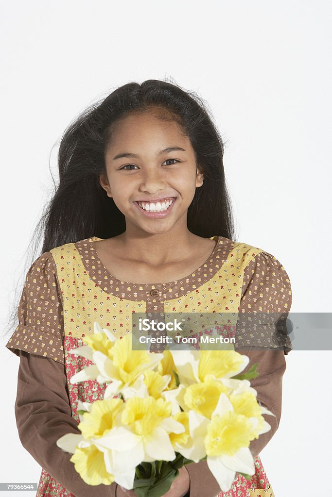Giovane ragazza in casa che tiene un mazzo di fiori - Foto stock royalty-free di 10-11 anni