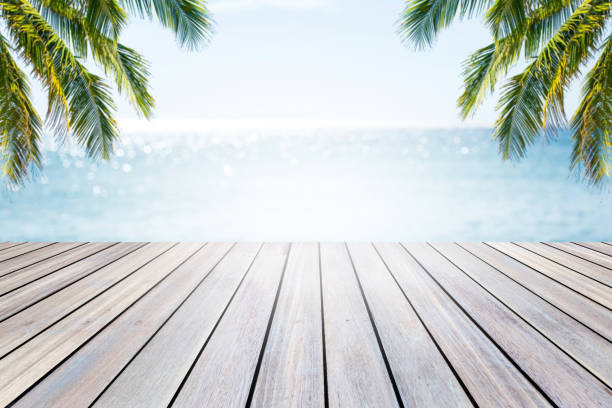 istock Empty wooden table and palm leaves on beach blurred background. 800083116