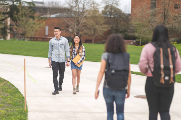 istock Multiethnic group of college students hang out in between classes on sidewalk, talking and smiling 800133916