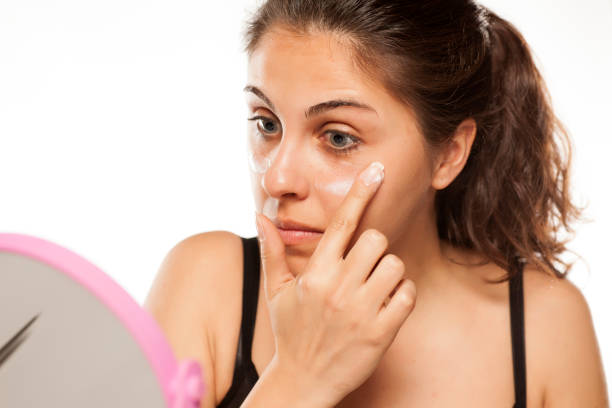 istock young beautiful women apply cosmetics on her face 800178568