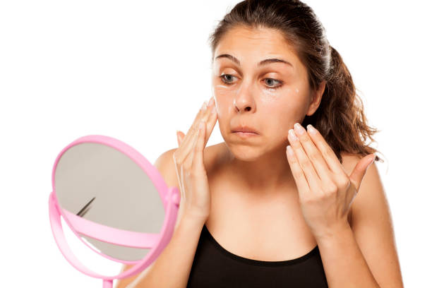 istock young beautiful women apply cosmetics on her face 800178756