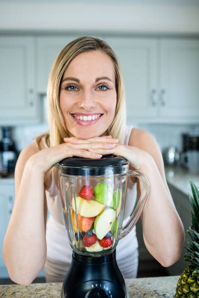 istock Pretty blonde woman preparing a smoothie 800190844