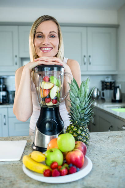 istock Pretty blonde woman preparing a smoothie 800192878