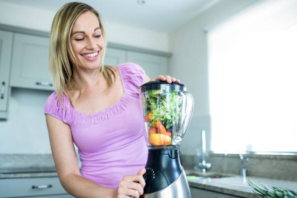 istock Pretty blonde woman preparing a smoothie 800223666