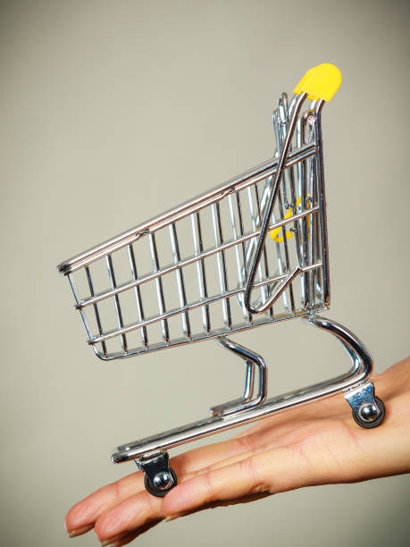 istock Woman hand holding small tiny shopping cart 800279740