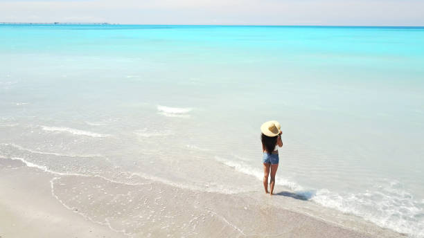 istock woman standing on the caribbean beach 800286572