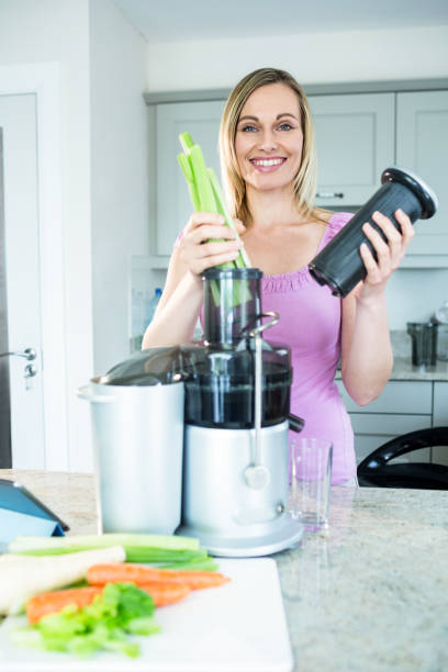 istock Blonde woman preparing a smoothie in the kitchen 800289752