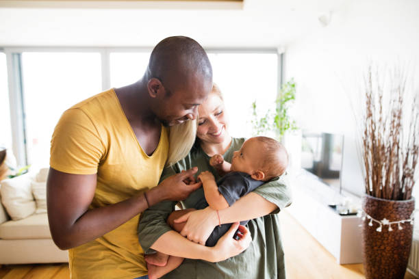 interracial junge familie mit baby söhnlein zu hause. - baby beautiful little boys carrying stock-fotos und bilder