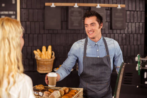 istock Smiling waiter serving a coffee to a customer 800290544