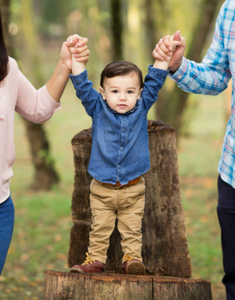 istock Little boy standing and holding parents with hands 800294146